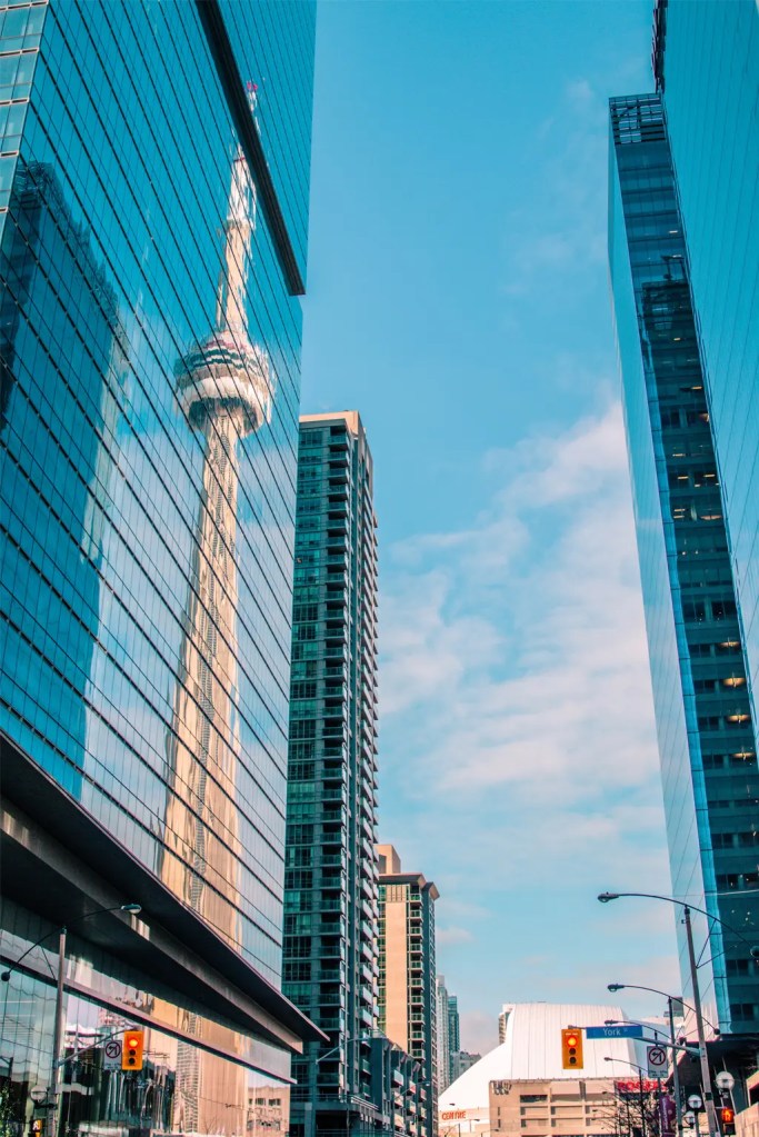 office buildings in downtown toronto with a reflection of the CN Tower in the windows