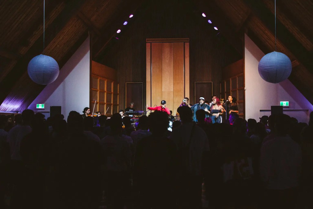 Wide shot of performers on stage from behind the audience