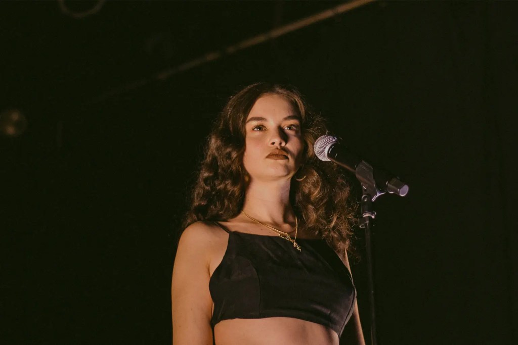 Sabrina Claudio staring into the distance in front of her mic