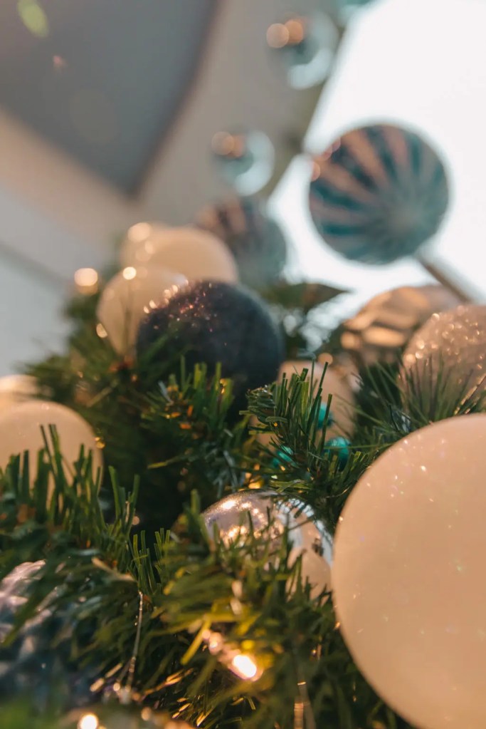 low angle close up of christmas tree with white and teal circular ornaments