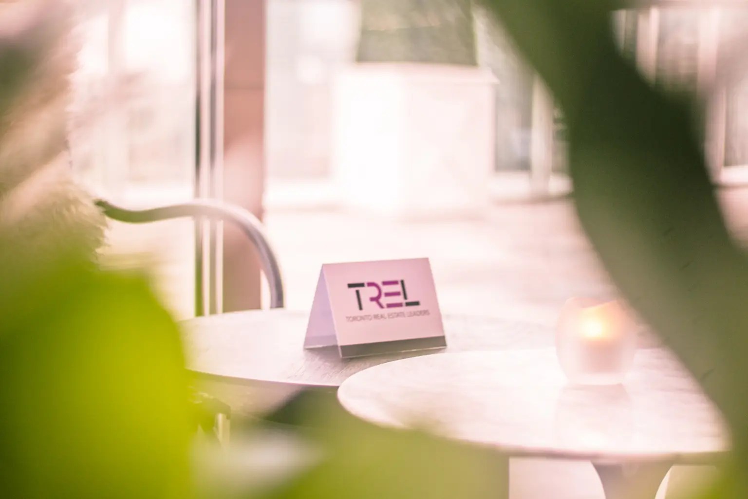 out of focus foliage in the foreground with an in focus "TREL" name card placed in the centre of an event table